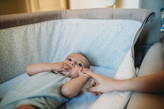 four month old baby boy lying awake in next to me crib
