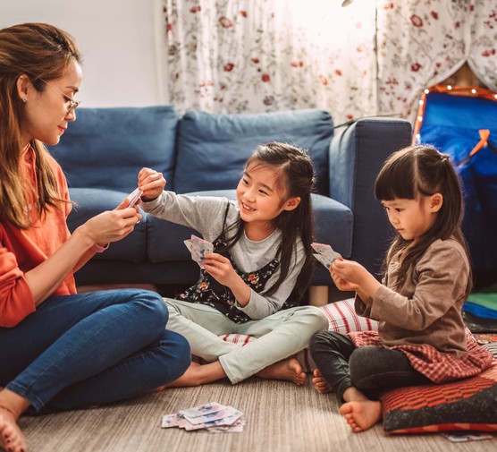 mum playing cards with her two daughters