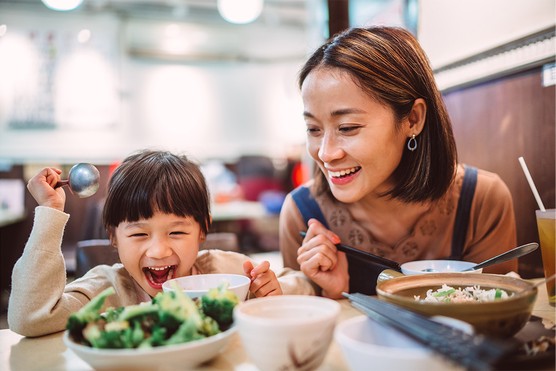 Mother and daughter eating at restaurant