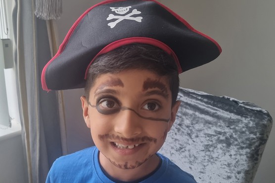 Child with their face painted a pirate and wearing a pirate hat