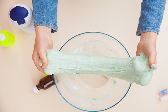 2 hands pulling slime over a bowl