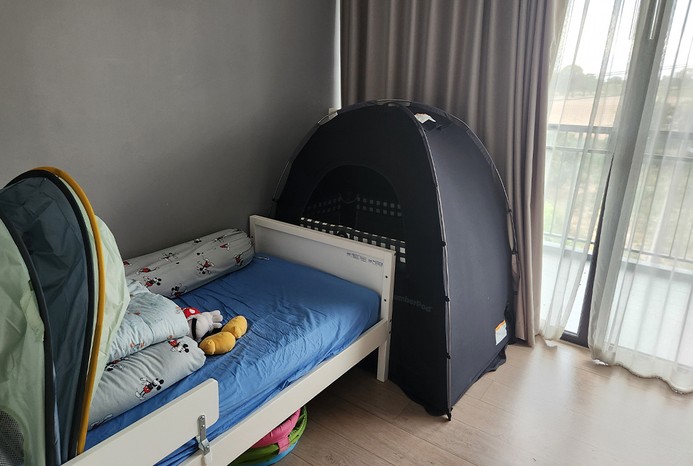 SlumberPod Blackout Sleep Tent set up in the corner of the room