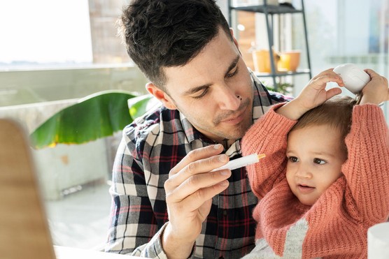 little girl refusing to take medicine her dad is giving her in a syringe