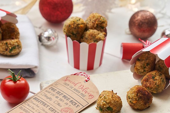 mini turkey balls in a cardboard bowl surrounded by Christmas decorations