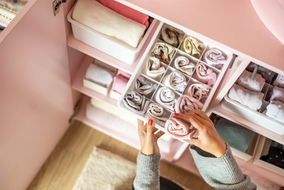 Woman Arranging Clothes In Wardrobe