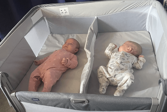 Babies asleep in Chicco Next2Me Twin crib with drop-down side