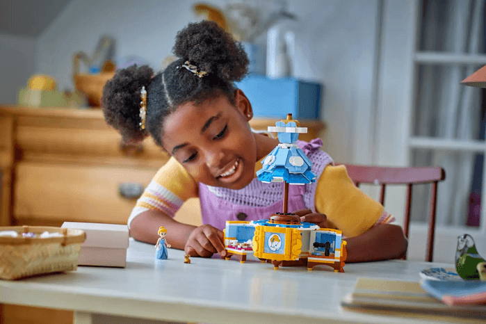 Little girl playing with LEGO Cinderella's Dress model